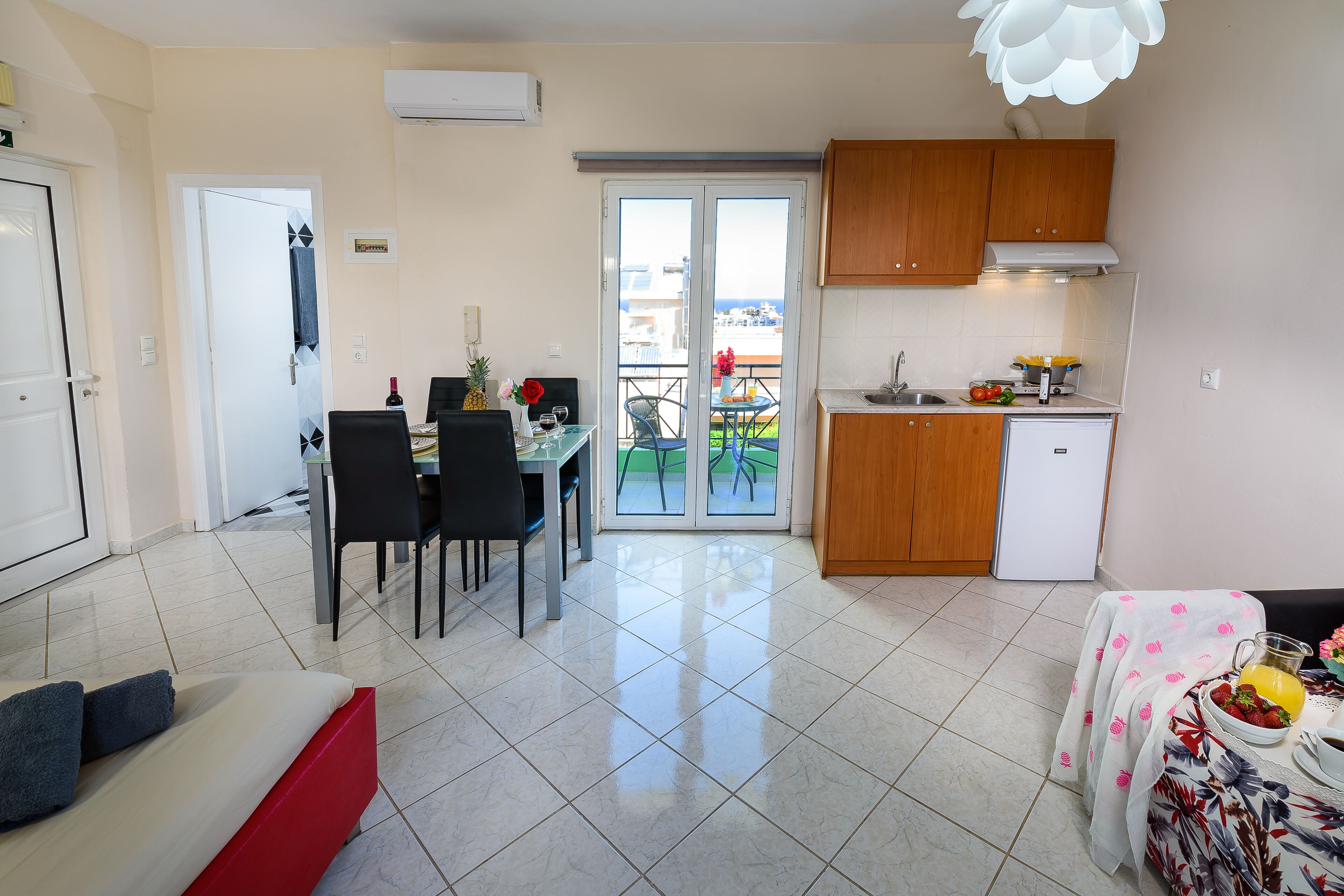 Un espacio habitable compacto con comedor, kitchenette y un balcón con vistas.