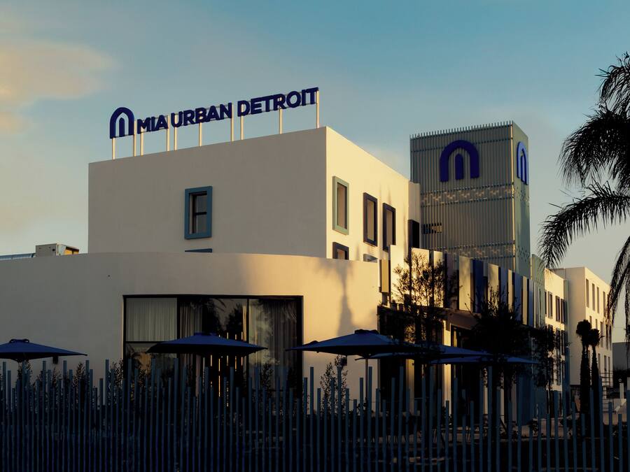 A modern building with a sign reading "MIA URBAN DETROIT" and a tall structure with a similar logo.
