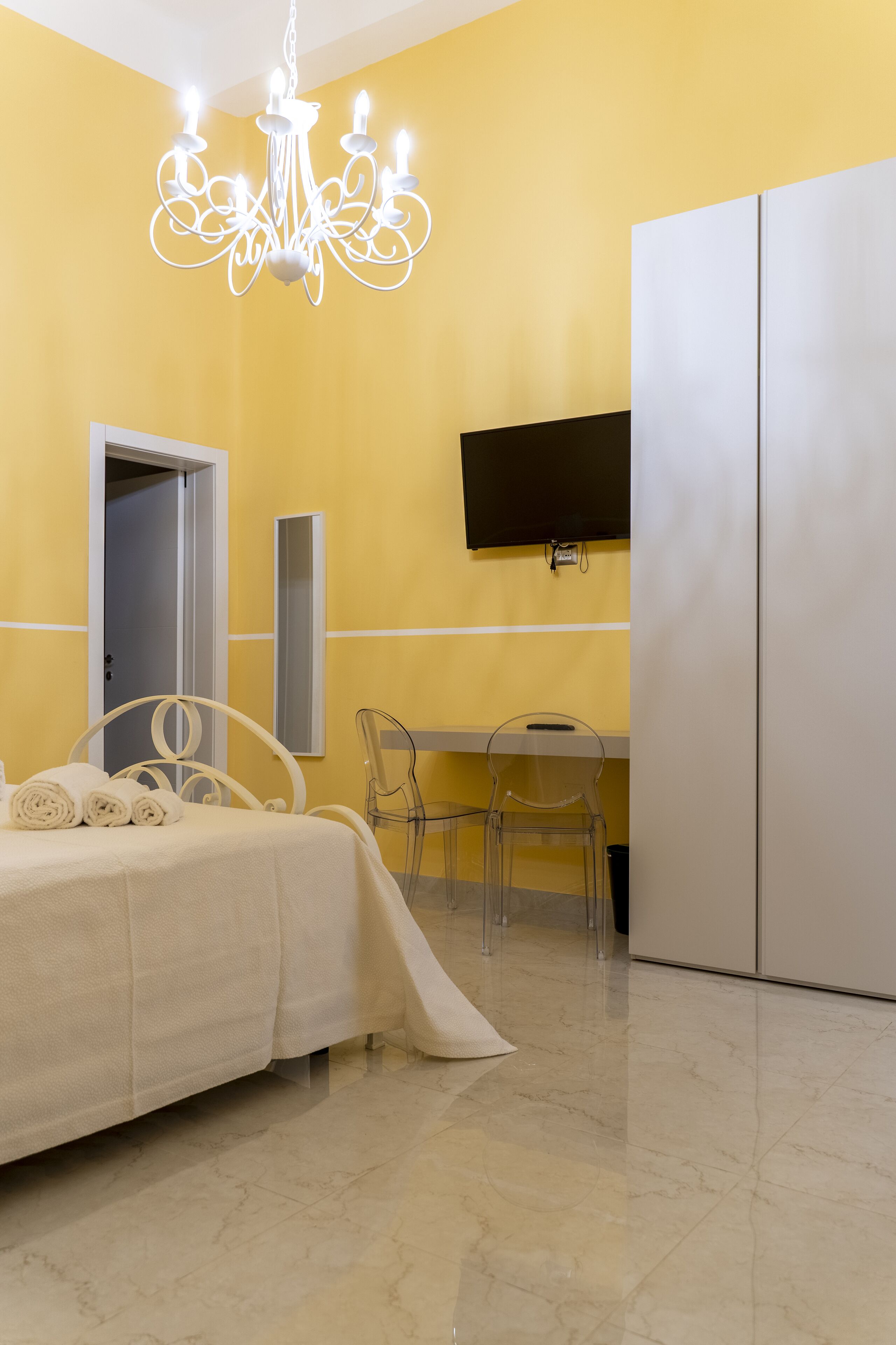 Una camera da letto con un letto, una scrivania, una sedia, un televisore e un armadio.