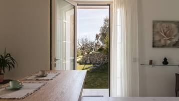 Ein Zimmer mit Blick auf einen Garten, durch einen geöffneten Durchgang.