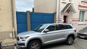 Ein silberner SUV steht in einer Wohnstraße.