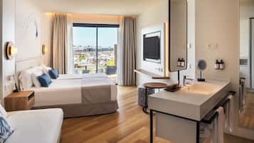Habitación de hotel con una cama grande, un escritorio, un televisor y un baño con espejo y lavamanos.