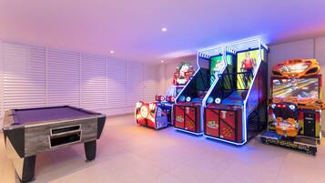 A pool table with arcade machines and a basketball game.