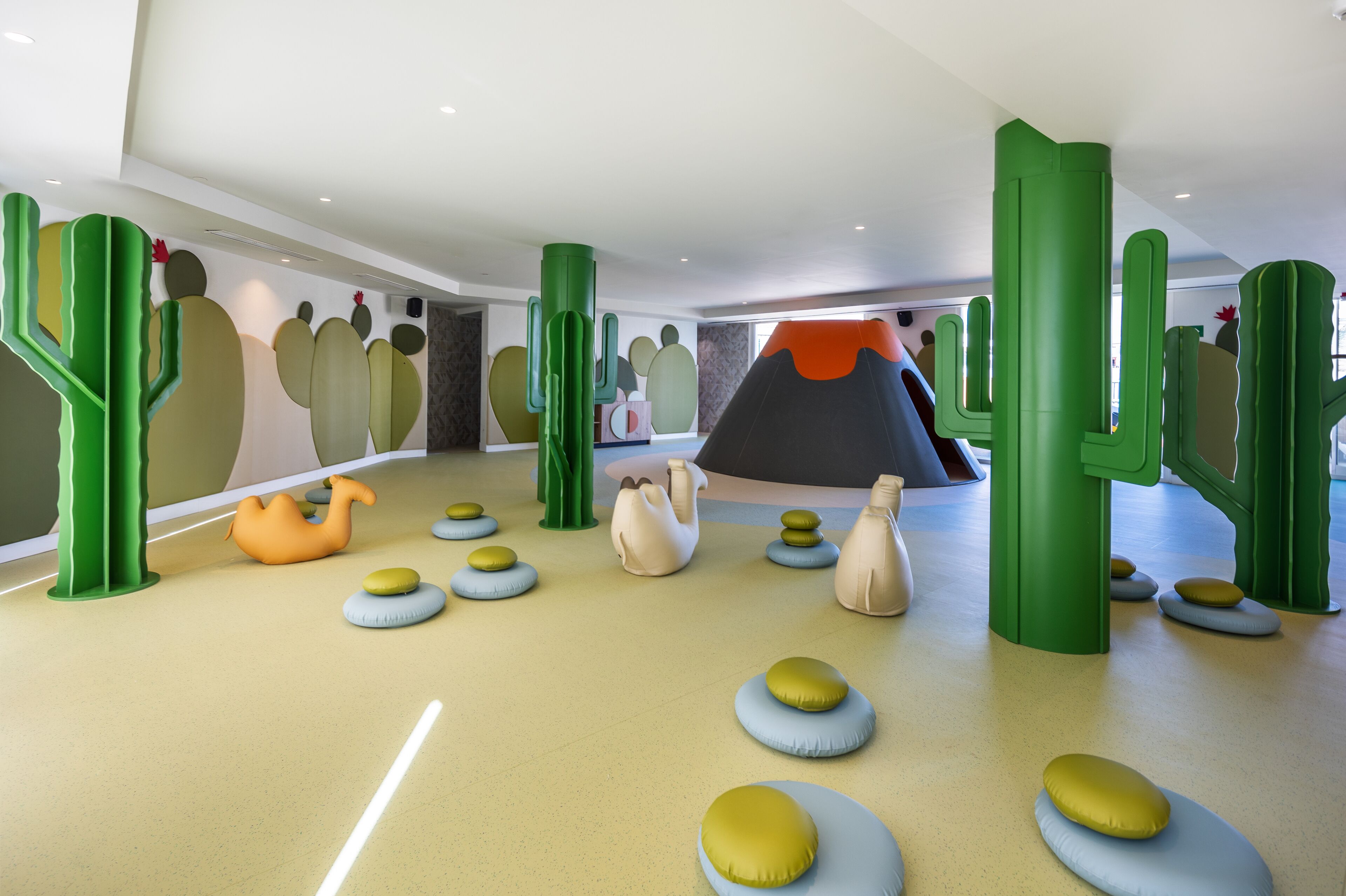 A play area with colorful, abstract structures and soft seating.