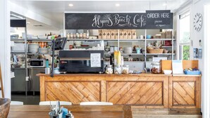 Un café avec un comptoir en bois, un menu écrit à la craie et une horloge au mur.