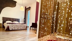 Una habitación con una cama, un piano y una pared decorada con adornos colgantes.