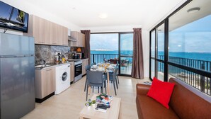 A modern apartment with a kitchen, dining area, and balcony with a sea view. - Islet Seafront Apartment Corner Terrace (St. Paul's Bay)