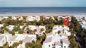 Zona residencial costera con casas y una playa al fondo.