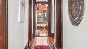 A hallway with a patterned carpet, wooden doors, and a decorative plate on the wall. - Luxurious King Room in Historic Boutique Inn (Winston-Salem)