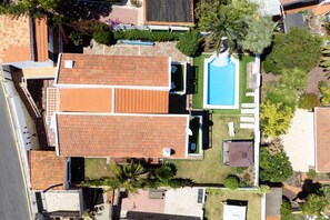 A residential area with a swimming pool, a covered patio, and a fenced yard.