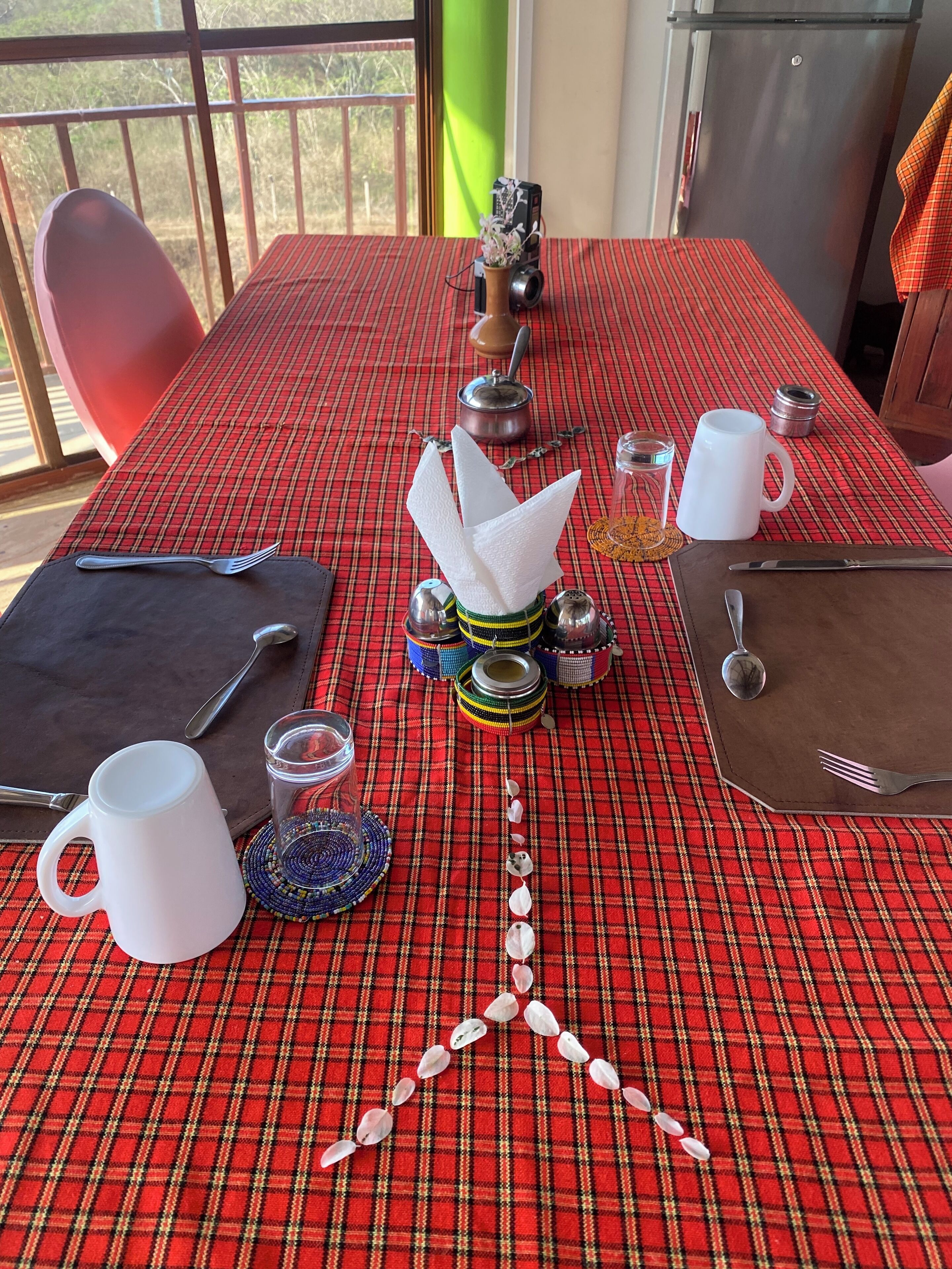 A dining table with a plaid tablecloth, various tableware, and decorative items.
