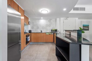 Fully equipped kitchen with central island, microwave, coffee maker, and toaster.
