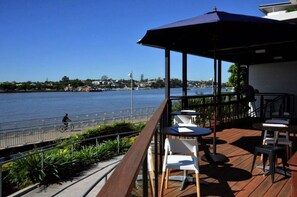 Enjoy dining or socializing on this waterfront terrace with a view of the calm body of water.