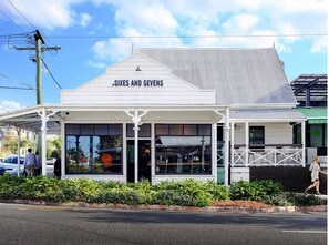 Welcome to Sixes and Sevens, a charming building with a gabled roof and classic entrance.