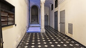 A hallway with a checkered floor, arched ceilings, and a staircase leading to an upper level. - Sui Tetti del Centro di Genova by Wonderful Italy (Genova)