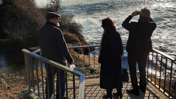 Blick auf einen Fluss mit Geländer und Stufen, die zum Wasser führen.
