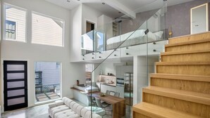 A modern interior with a staircase, a dining area, and a kitchen.