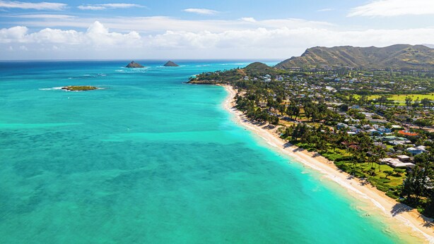 An aerial view of a coastal town with clear turquoise waters, a sandy beach, and lush greenery. - Hale Oahu Lic.#1990/NUC-1777/1778 BEACHFRONT KAILUA LUXURY (Kailua)