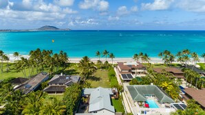 A coastal property with a swimming pool, multiple houses, and a beach with palm trees. - Hale Oahu Lic.#1990/NUC-1777/1778 BEACHFRONT KAILUA LUXURY (Kailua)