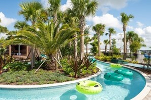 Ein Poolbereich mit Palmen, einer Holzkonstruktion und Schwimmreifen.