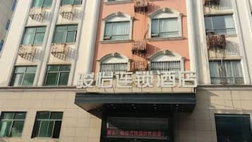 A hotel with a sign in a foreign language, multiple balconies, and a modern facade.