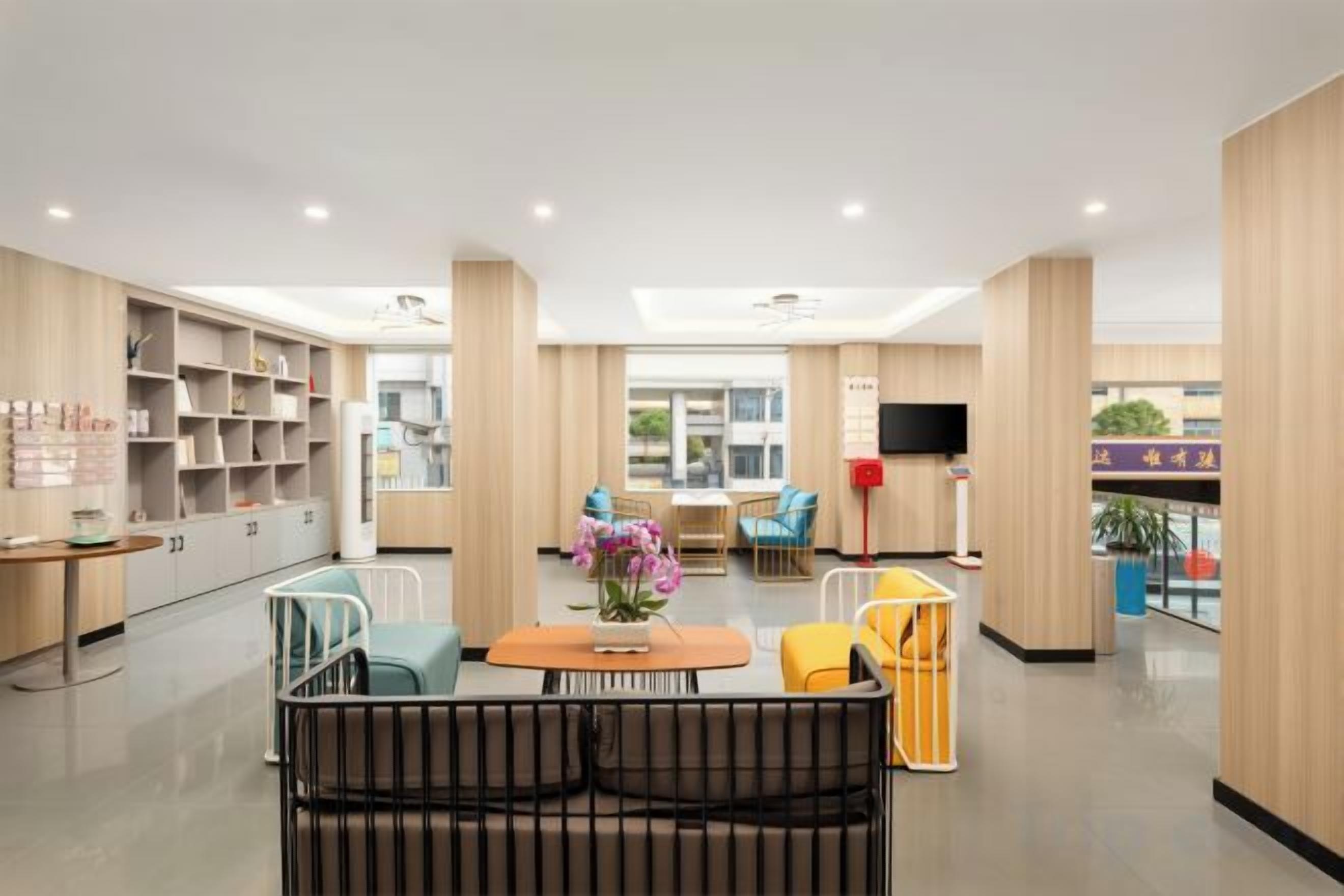 A modern interior with a central seating area, a children's play area, and a kitchen in the background.