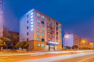 Un hotel de varios pisos con una entrada destacada y señalización.