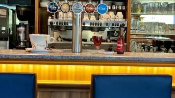 Un espace bar avec un comptoir, plusieurs robinets et une machine à café.