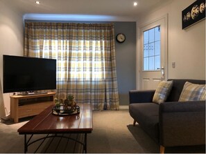 Relax in this stylish living room with a flat-screen TV, comfortable sofa, and decorative accents.