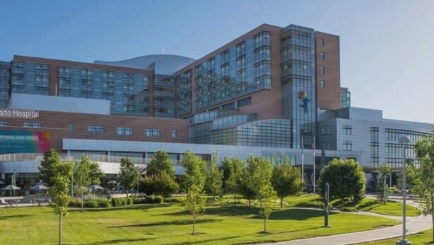 Un moderno edificio ospedaliero con facciata in vetro e un cortile curato.