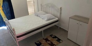 Cozy retreat with a single bed, white cabinet, and patterned rug.