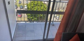 Enjoy the view from this balcony with a glass door, overlooking the parking area and surrounding landscape.