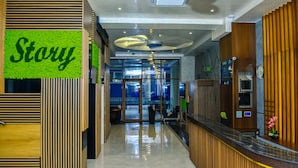 A hotel reception area with a modern design, featuring a reception desk, a 'Story' sign, and a glass door entrance. - Hotel Story (Skopje)