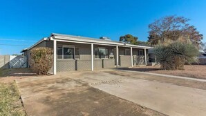 A single-story building with a covered porch, a brick facade, and a small garden area with a cactus. - Historic Scottsdale Home with Modern design (Scottsdale)