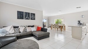 Ein modernes Wohnzimmer mit Ecksofa, Essbereich und Küche.