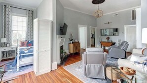 Ein geräumiges Wohnzimmer mit Kamin, einer Sofagarnitur und einem Essbereich.