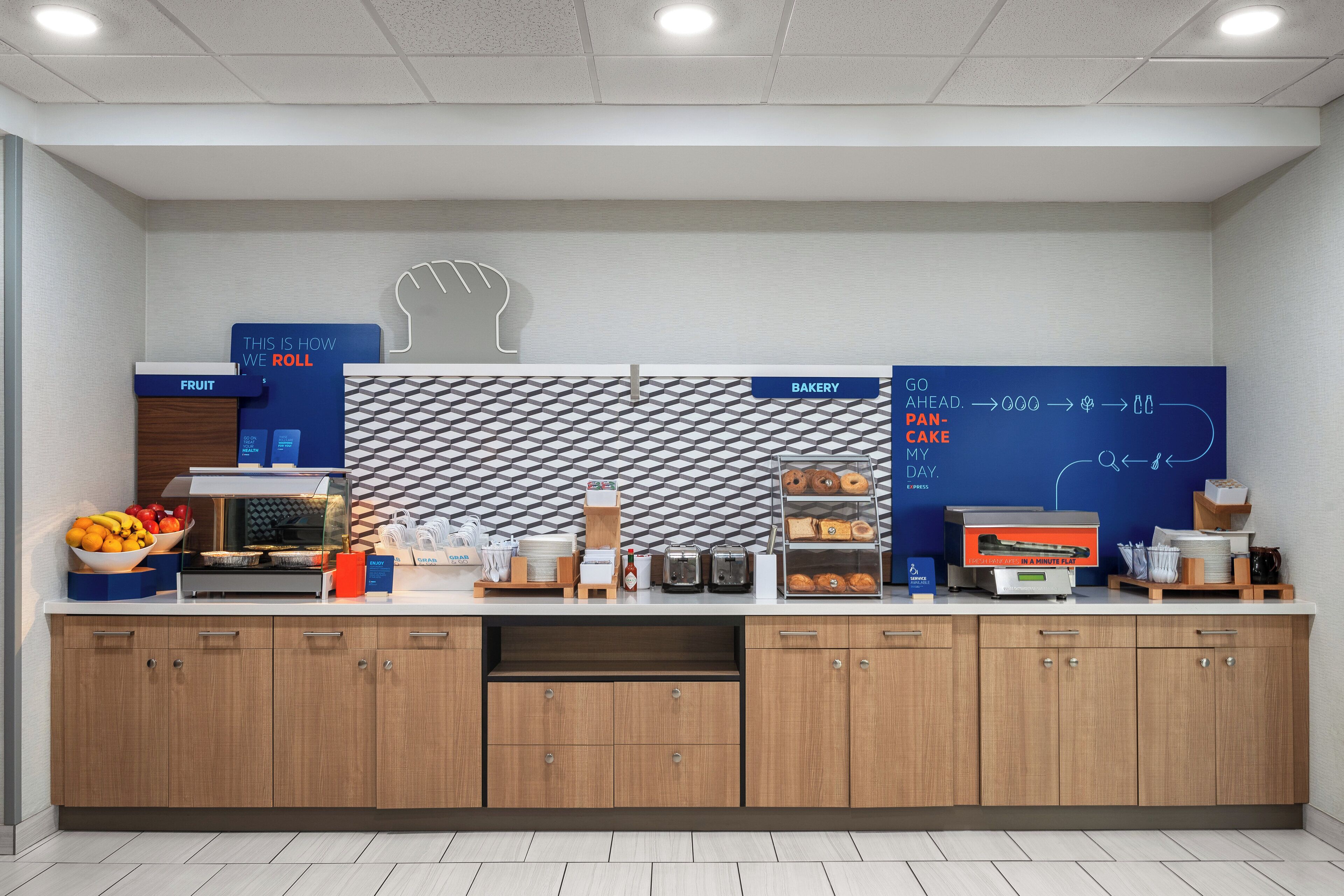 A modern kitchen with a fruit station, bakery, and a chalkboard with a handprint design.