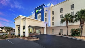 Entrada de hotel con diseño moderno, incluyendo un letrero destacado de Holiday Inn Express & Suites.
