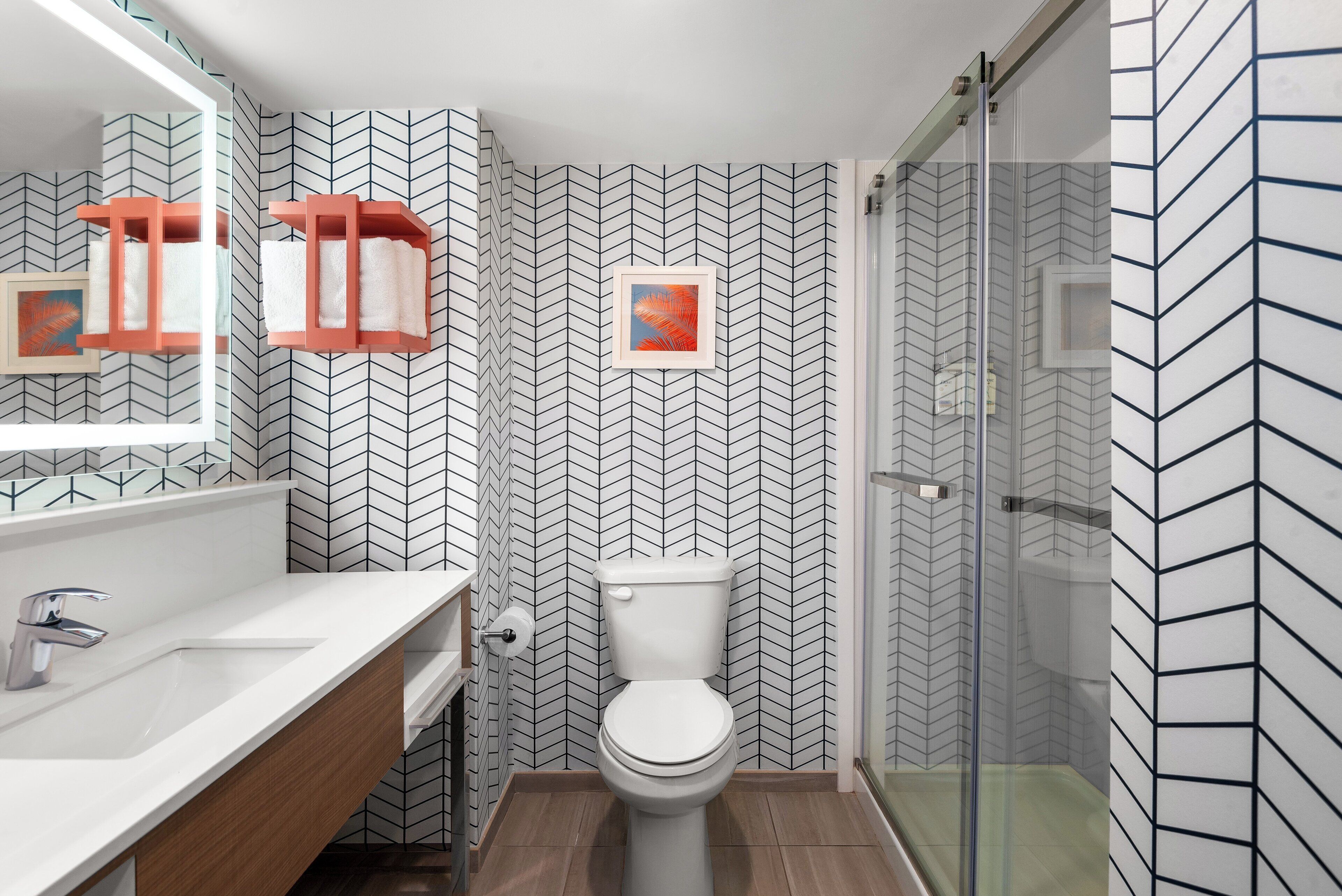 Un baño con lavamanos blanco, inodoro y cabina de ducha de vidrio.