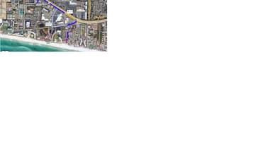 A satellite view of a coastal city with a prominent blue route.