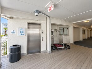 An interior corridor with bunk beds, an elevator, and exit signs. - Beachfront Resort Escape | 6 Pools + Indoor Pool | Sleeps 6 (Gulf Shores)