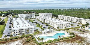 A resort with multiple white buildings, a central swimming pool, and a beach area. - Romantic Beach Escape | Gulf Shores Plantation (Gulf Shores)
