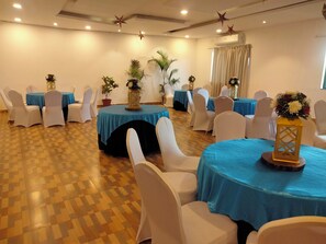 A room with round tables covered in blue tablecloths, white chairs, and potted plants. - Calangute Villae By Urban Getaway (Calangute)