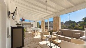 An open-plan living area with a dining table, sofas, and a small refrigerator. - 3191 Villa Sergi by Perle di Puglia (Gagliano del Capo)