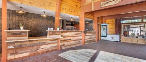 A reception area with wooden paneling, a stone wall, and a vending machine.