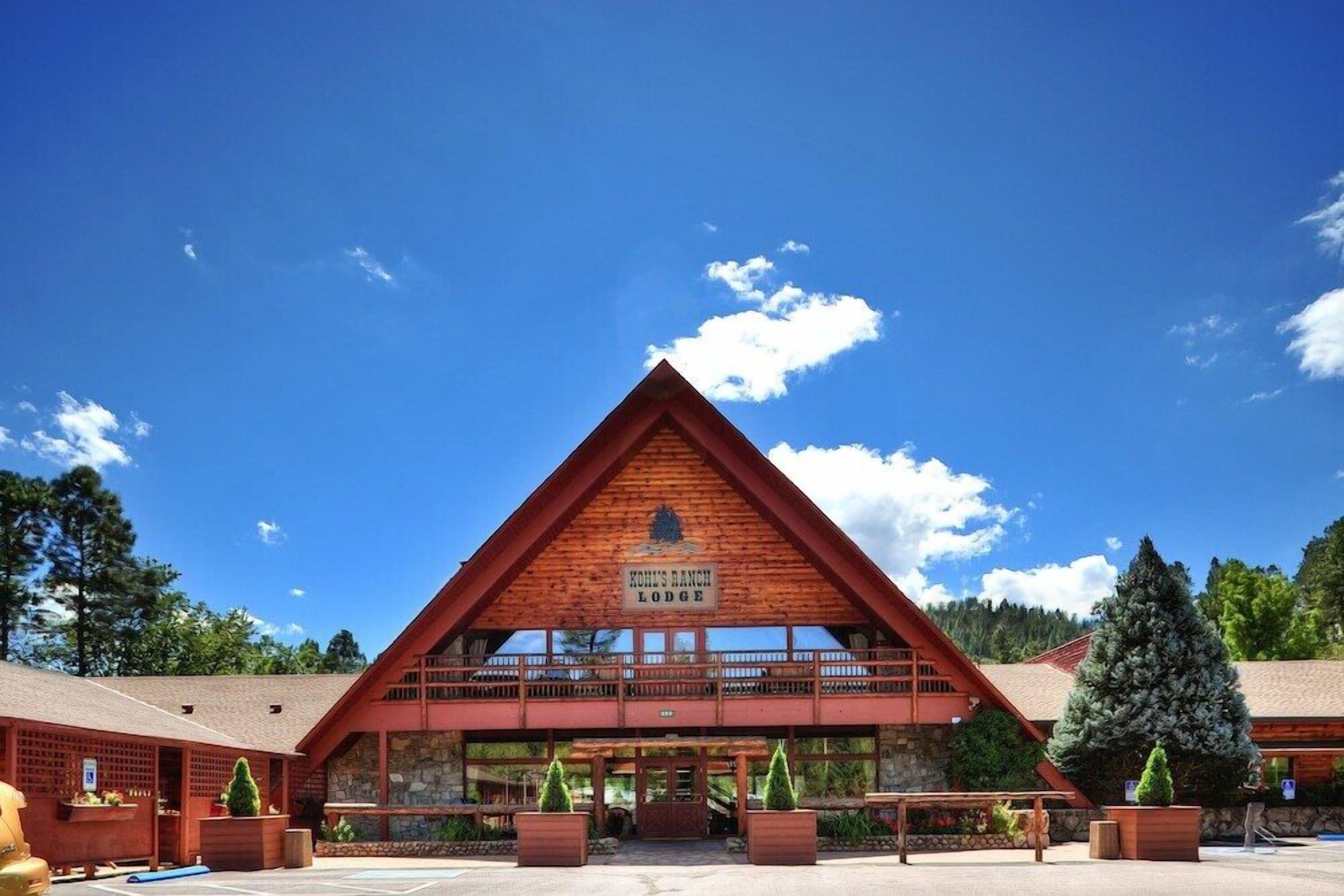 A large, triangular wooden lodge with a sign reading "Koh's Ranch Lodge".