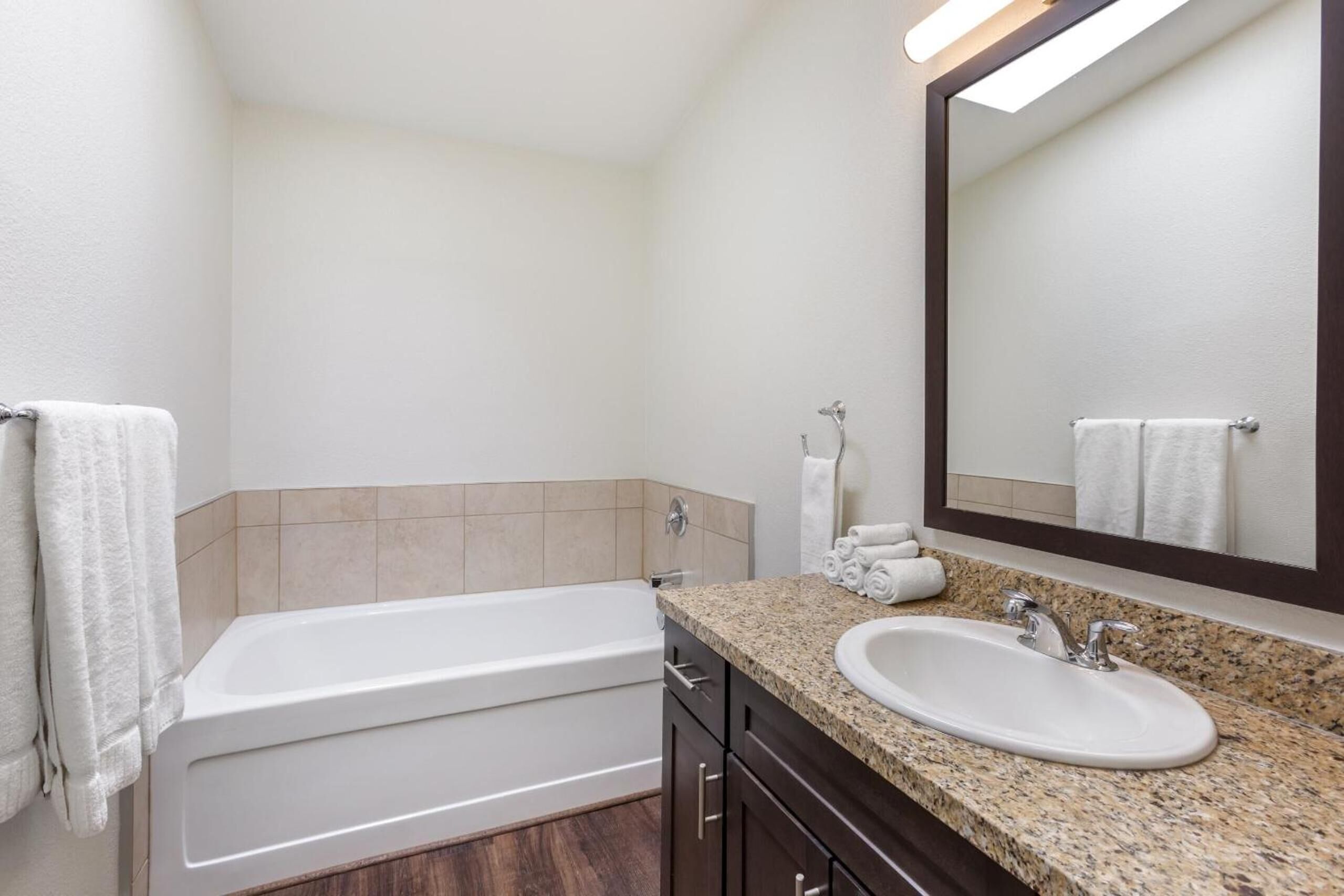 Une salle de bain avec une baignoire, un lavabo et un miroir.