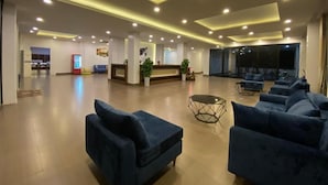 A spacious lobby with a reception desk, multiple seating areas, and a large screen. - Vang Vieng Topview Hotel (Vang Vieng)