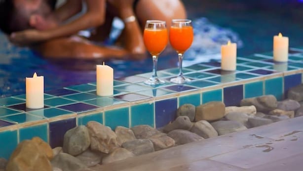 A couple in a pool with candles and drinks on the edge. - Vang Vieng Topview Hotel (Vang Vieng)