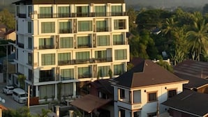 A multi-story hotel with a modern design, featuring balconies and large windows. - Vang Vieng Topview Hotel (Vang Vieng)